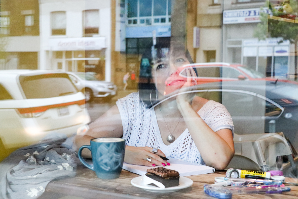 Jamie Ridler sitting in a coffee shop looking out the window